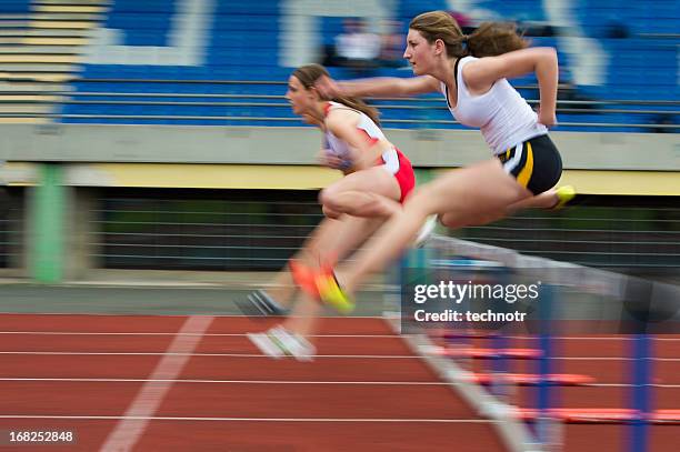 las atletas femeninas en obstáculo raza 100 m - carreras de obstáculos prueba en pista fotografías e imágenes de stock