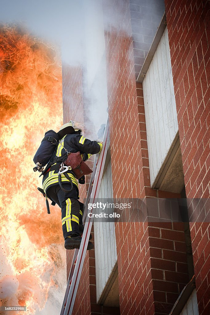 Voll ausgestattete Feuerwehrmann auf einer Leiter