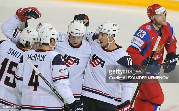 Players celebrate scoring next to Russia's forward Denis Kokarev during a preliminary round game Russia vs USA of the IIHF International Ice Hockey...