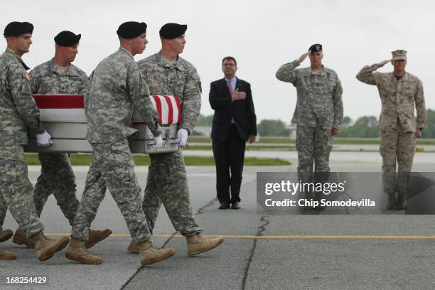 Army carry team carries the flag-draped transfer case with the remains of Army 1st Lt. Brandon Landrum across the tarmac at Dover Air Force Base as...