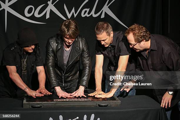 Rockwalk director Dave Weiderman assists Bassist Robby Takac, vocalist / guitarist John Rzeznik and drummer Mike Malinin of Goo Goo Dolls as they are...