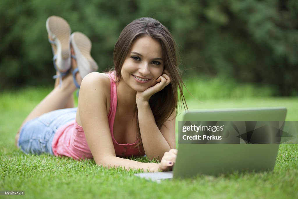 Young woman using laptop in park