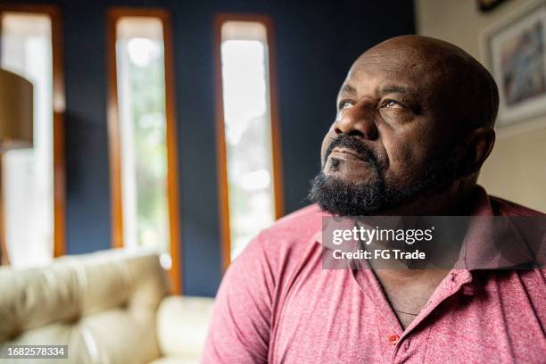 sad mature man contemplating at home - introspection stock pictures, royalty-free photos & images