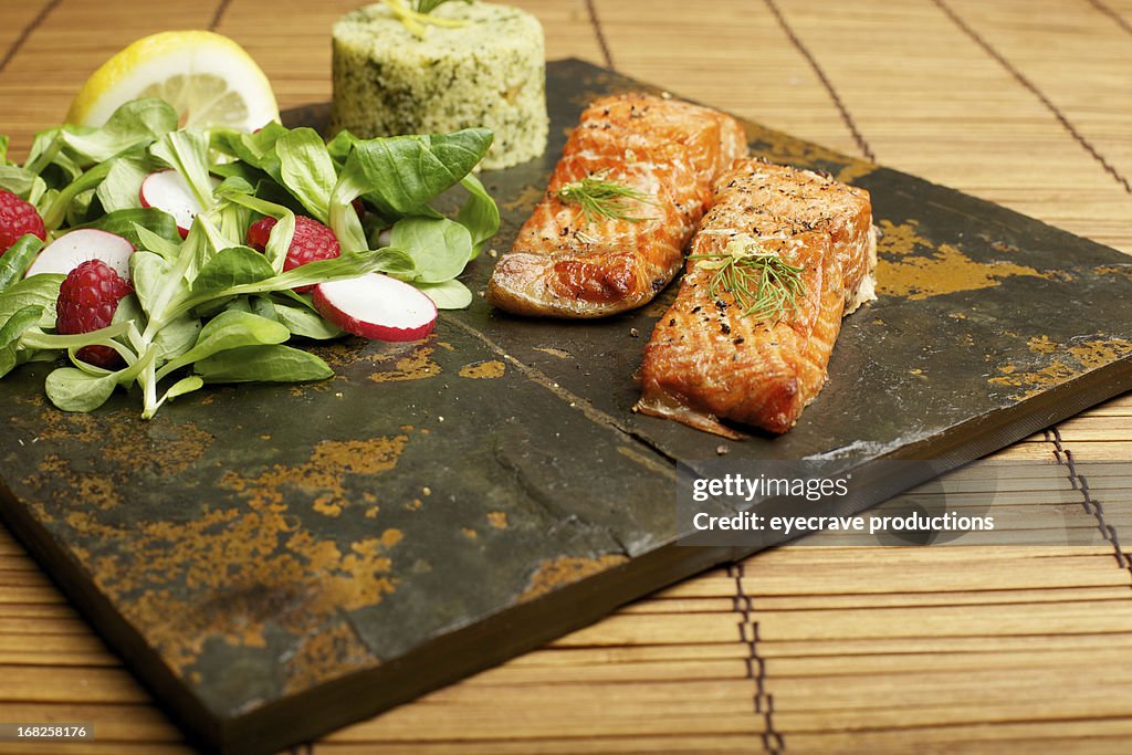 Slate tile plated grilled wild Salmon fillet arugula and couscous