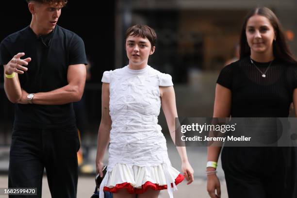 Maisie Williams was seen wearing a white short dress and with a beige and red skirt qs well as a dark bag before the Stefan Cooke Fashion Show during...