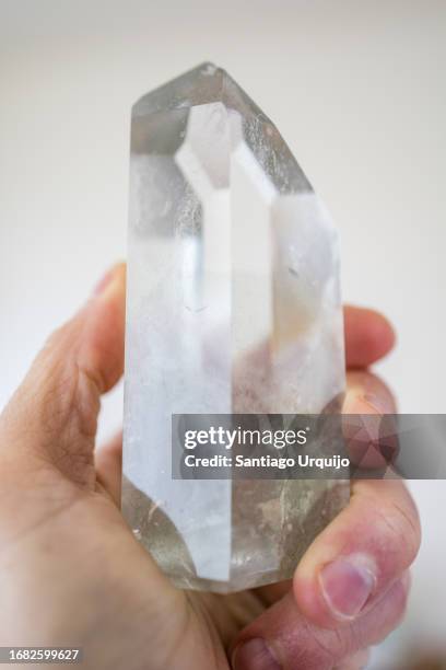 human hand holding a clear quartz crystal - healing crystals stock pictures, royalty-free photos & images