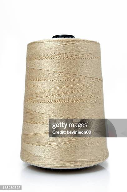 a big spool of gold sewing thread - threading stock pictures, royalty-free photos & images
