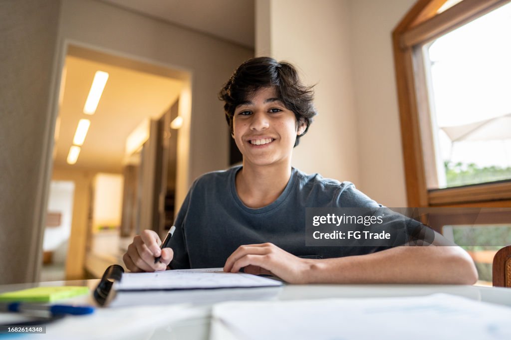 Portrait of a teenager boy studying at home