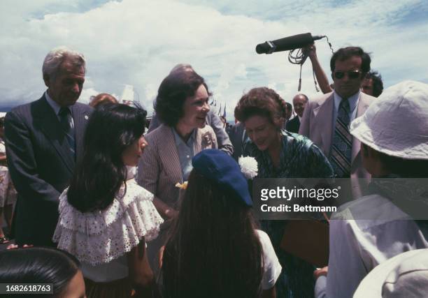 First Lady Rosalynn Carter and Marjorie Oduber , wife of the Costa Rican President, talk with schoolchildren at San Jose Airport in Costa Rica, May...