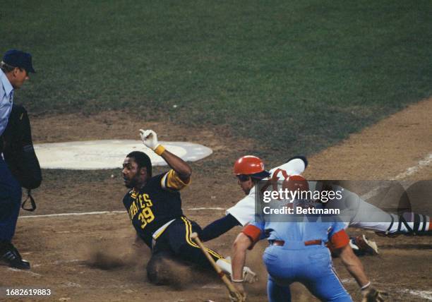 Dave Parker slides home as Carlton Fisk makes tag in vain during the 1977 Major League Baseball All-Star Game at Yankee Stadium in New York, July...