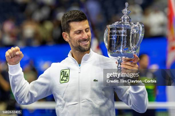 September 10: Novak Djokovic of Serbia with the winners' trophy and wearing a tracksuit representing his 24th grand slam win after his victory...