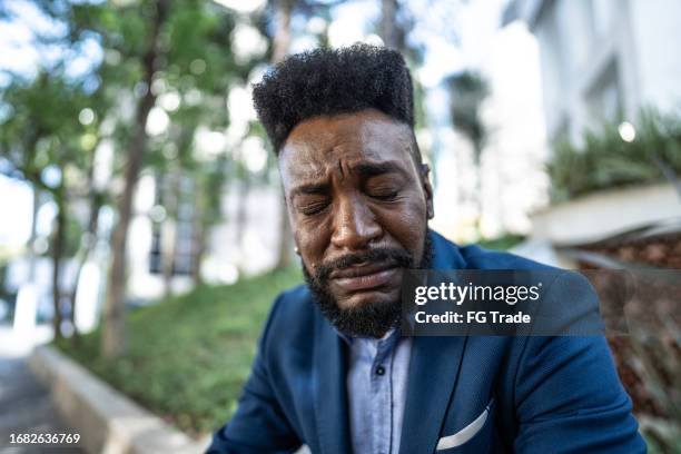 trauriger mittelerwachsener geschäftsmann, der im freien weint - weinen stock-fotos und bilder