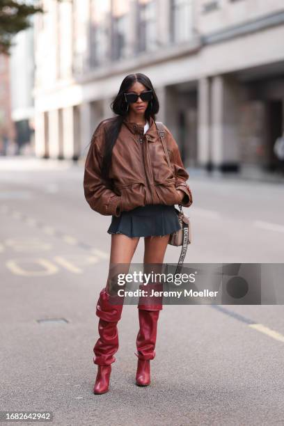 Fashion Show Guest was seen wearing red high heels, a short grey skirt, a white top, a beige Loewe Bag, dark Yve Saint laurent shades and an...