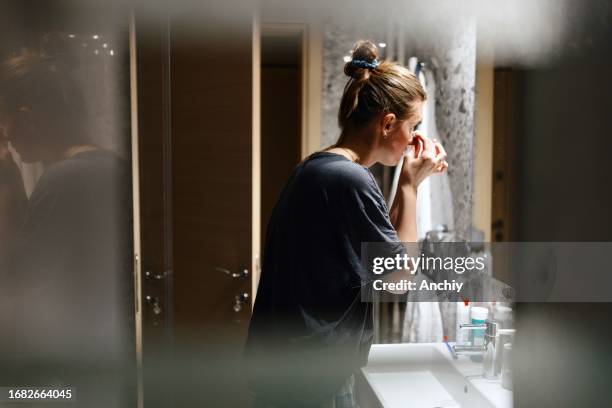 lovely woman taking of her make-up in the bathroom - woman make up face wipes not men stock pictures, royalty-free photos & images