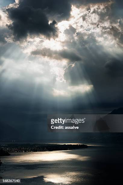 dramatic sky with sunbeams over lago maggiore, switzerland - dramatic sky sea stock pictures, royalty-free photos & images