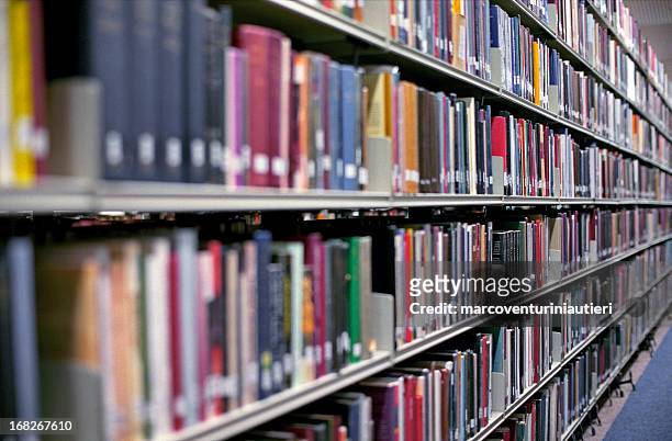 library bookshelves filled with rows of books - bookshelf stock pictures, royalty-free photos & images