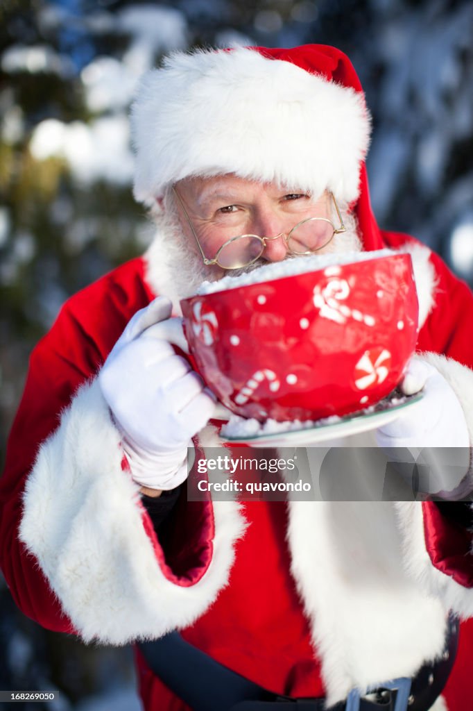 Joyeux Père Noël en sirotant cacao de grandes tasses dans la neige