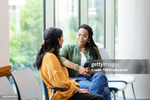 unrecognizable young woman shares problems with female therapist - saúde mental imagens e fotografias de stock