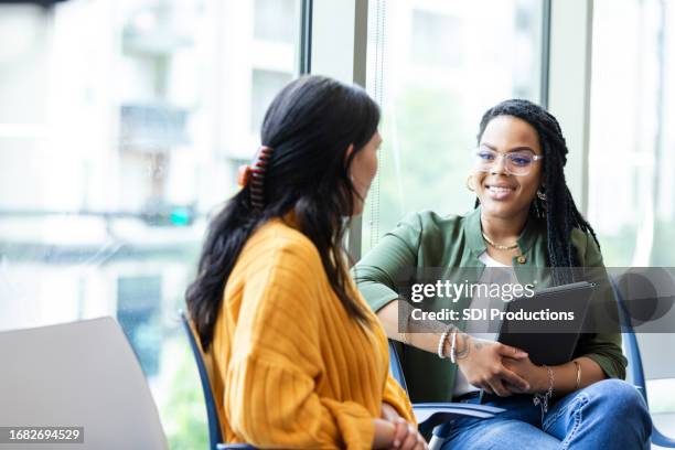 female therapist listens attentively to young female student - student advisor stock pictures, royalty-free photos & images