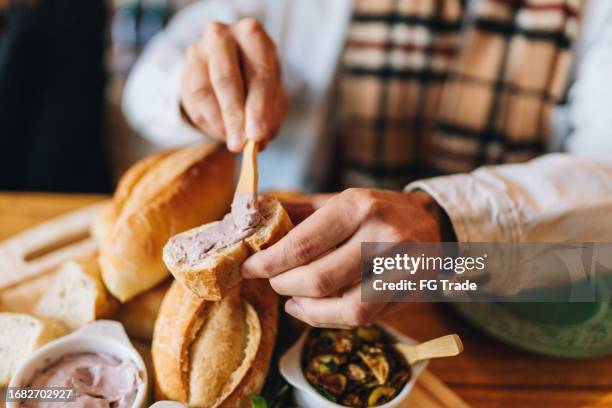 mains masculines étalées sur une tranche de pain - terrine photos et images de collection