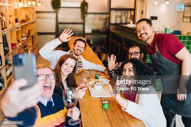 happy friends taking a selfie at a restaurant - online happy hour stock pictures, royalty-free photos & images