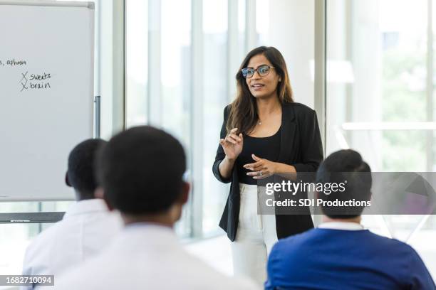 female hospital administrator leads staff meeting - american influencer stock pictures, royalty-free photos & images