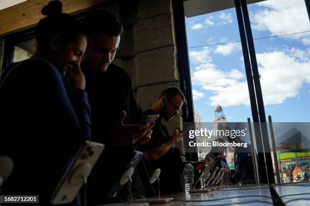 Customers inspect the new range of iPhone 15 smartphones inside the Apple Inc. Puerta del Sol store on the first day of sale of the iPhone 15...