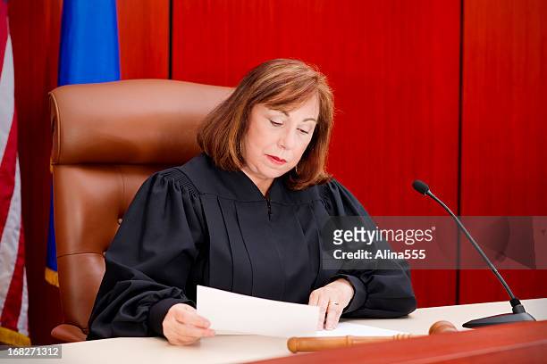 terceira feminina de juiz na mesa de leitura de papel - supremo tribunal imagens e fotografias de stock