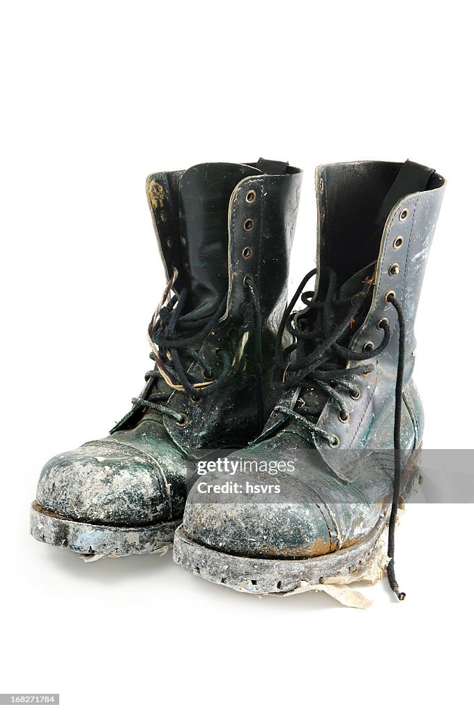 Old dirty boots isolated on white background