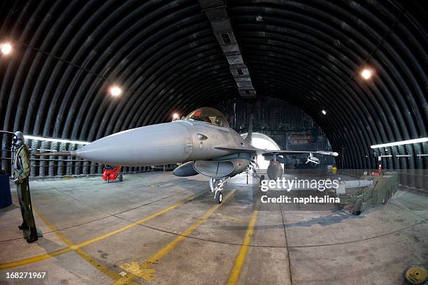 f16 fighter in military hangar - airplane hangar stock pictures, royalty-free photos & images