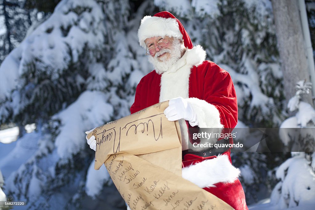 Cheerful Santa Claus Checking His List Outdoors in Winter Snow