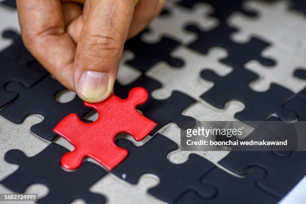 holding a red final piece of the jigsaw. - easy solutions stock pictures, royalty-free photos & images
