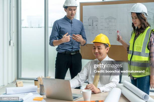 construction worker and engineer discussing project in site office. - tijdelijk gebouw stockfoto's en -beelden