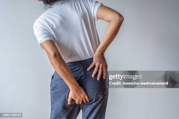 woman with hemorrhoids holding her ass in pain. - woman hemorrhoids fotografías e imágenes de stock