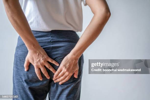 woman with hemorrhoids holding her ass in pain. - woman hemorrhoids fotografías e imágenes de stock