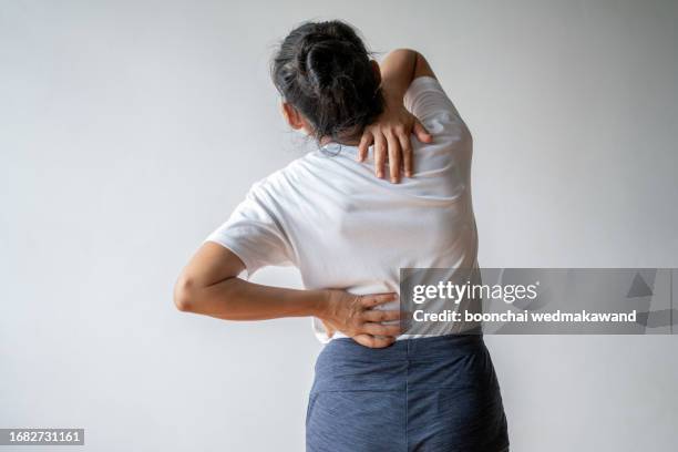 woman experiencing pain in her neck and back. - sezione superiore foto e immagini stock