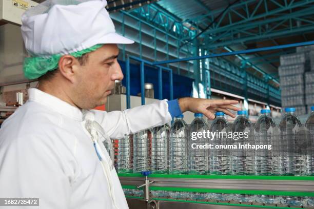 drinking water quality check the bottle of drinking water flow on the conveyer. - draft first round stock pictures, royalty-free photos & images