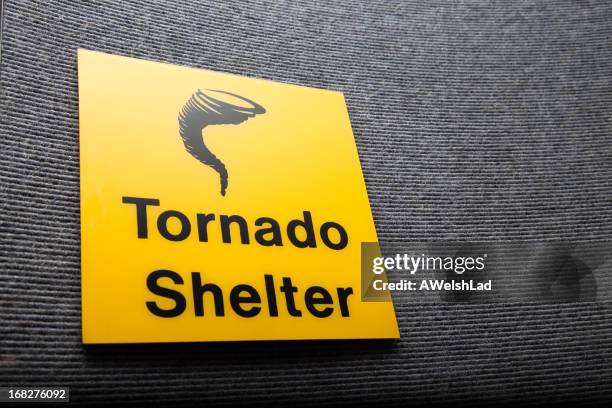 yellow sign got a tornado shelter on a wall - windscherm stockfoto's en -beelden