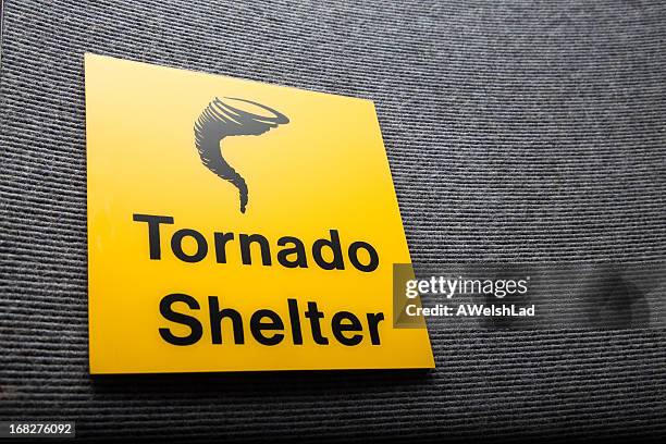 yellow sign got a tornado shelter on a wall - wind shelter stock pictures, royalty-free photos & images