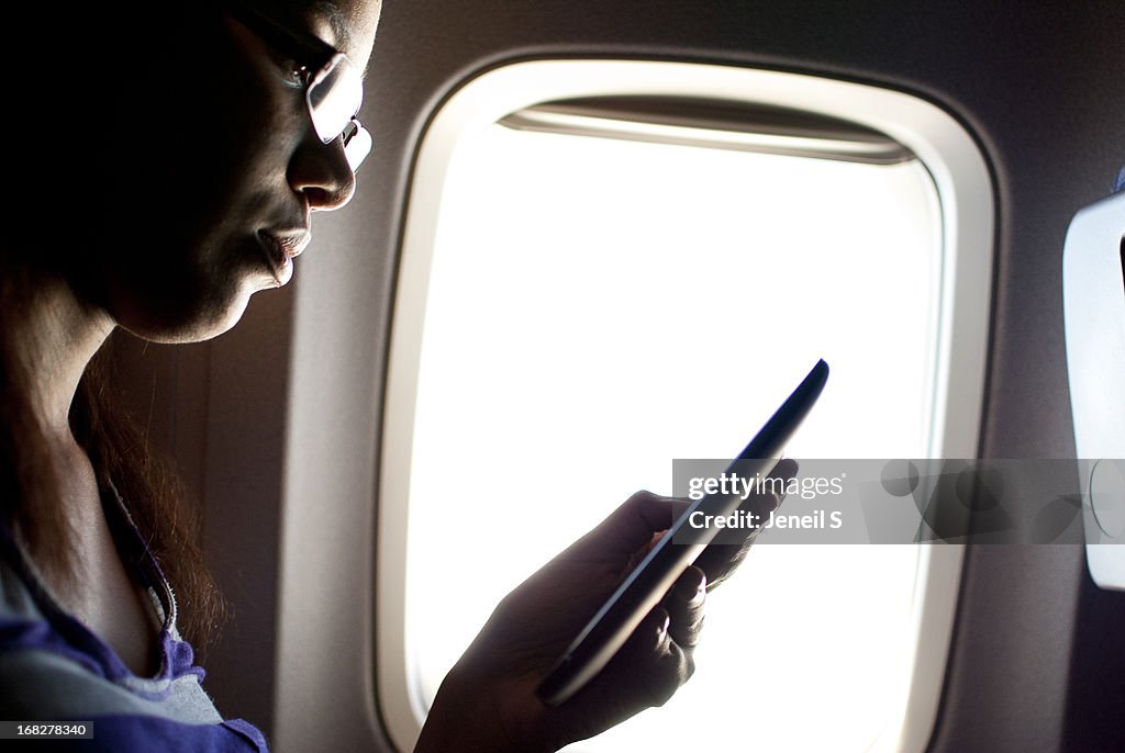 A woman using an ereader on a plane