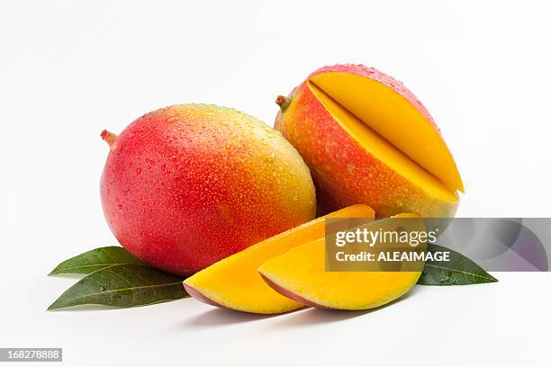 fresh slices of mango on a bed of leaves - bed on white stock pictures, royalty-free photos & images