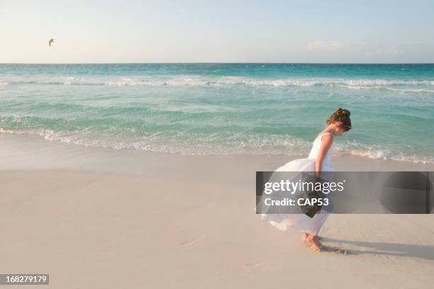 flor menina a andar na praia durante o dia de casamento - vestido de noiva imagens e fotografias de stock