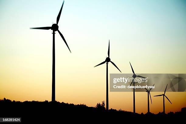 molinos de viento en una fila al atardecer - molino de papel fotografías e imágenes de stock