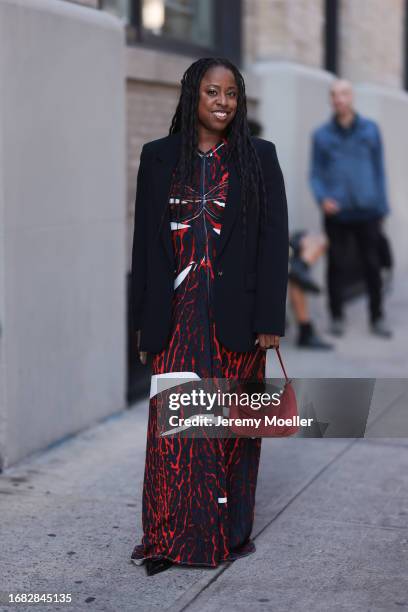 Guest is seen outside Brandon Maxwell show wearing navy blue blazer, white, red and blue patterned dress, black Prada nylon hobo handbag and black...