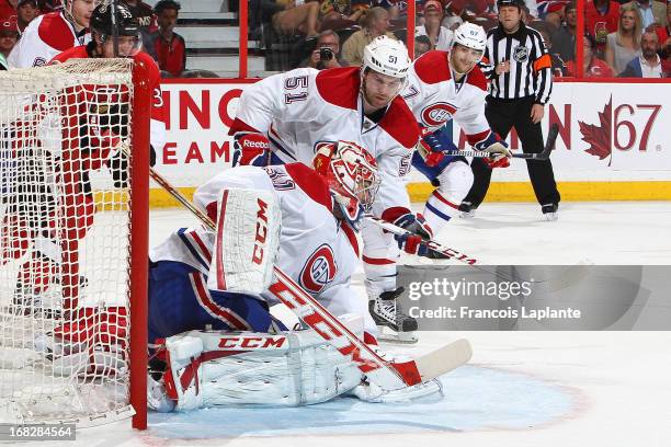 Carey Price of the Montreal Canadiens makes a save as David Desharnais and Max Pacioretty defend against the Ottawa Senators in Game Three of the...