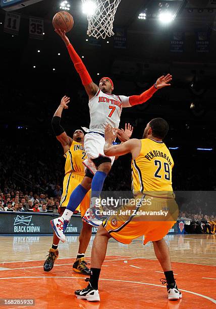 Carmelo Anthony of the New York Knicks drives between Jeff Pendergraph and David West of the Indiana Pacers during Game Two of the Eastern Conference...