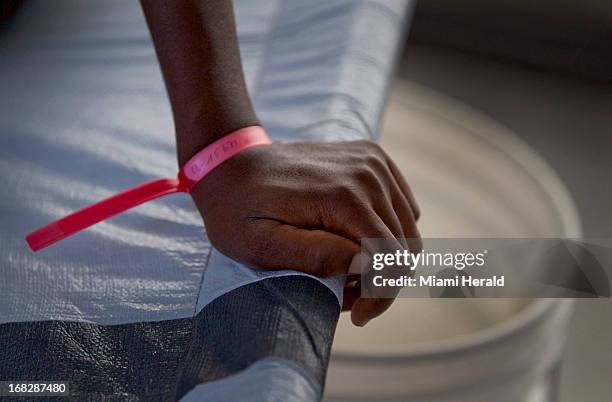 Young woman's hand grips the side of a specially designed Cholera cot as she is being treated at the Doctor's Without Borders Cholera Treatment...