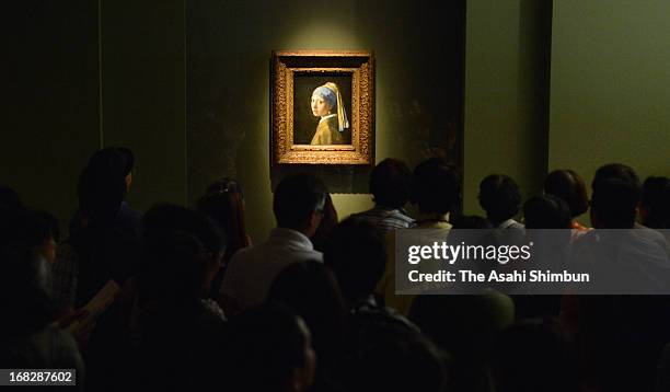 Visitors watch Johannes Vermeer's 'Girl with a Pearl Earring' at the 'Masterpieces from the Royal Picture Gallery Mauritshuis' exhibition at Kobe...