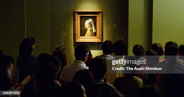 Visitors watch Johannes Vermeer's 'Girl with a Pearl Earring' at the 'Masterpieces from the Royal Picture Gallery Mauritshuis' exhibition at Kobe...