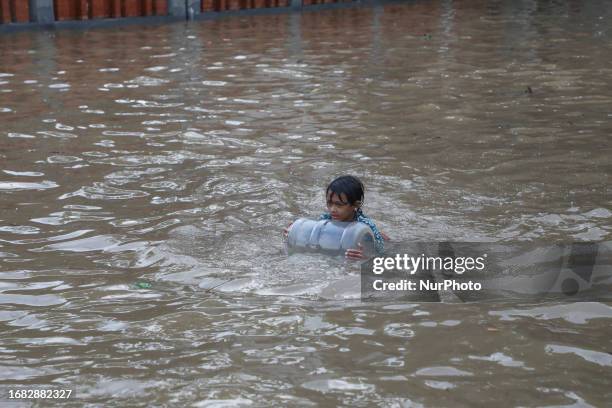 Children plays on a flooded road after heavy rains in Dhaka, Bangladesh on September 22, 2023.